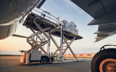 Preparation before flight. Loading of cargo containers to airplane at airport.